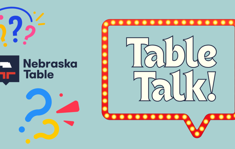 Graphic reading "Table Talk!" encase inside a light up speech bubble with the Nebraska Table logo and stylized question marks on the left hand side