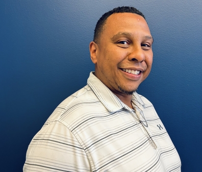 A headshot of a man in a white striped shirt